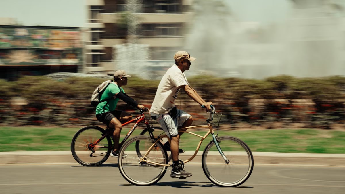 Two cyclists enjoying a sunny ride in Guadalajara, Mexico cityscape.